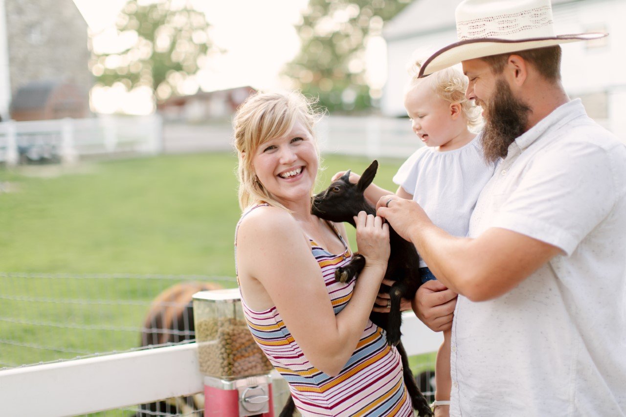 People playing with baby goats.