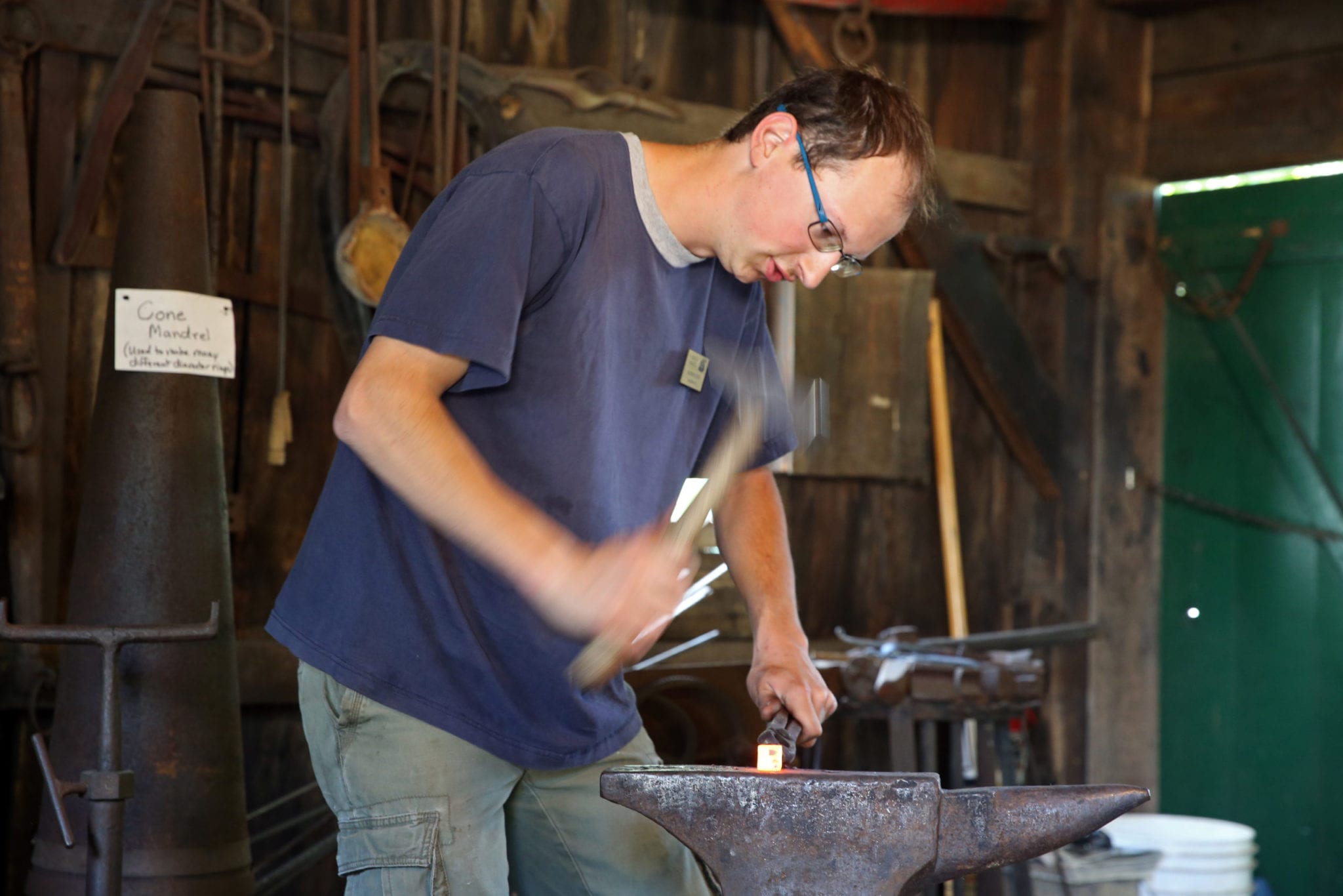 A blacksmith shaping metal on an anvil.